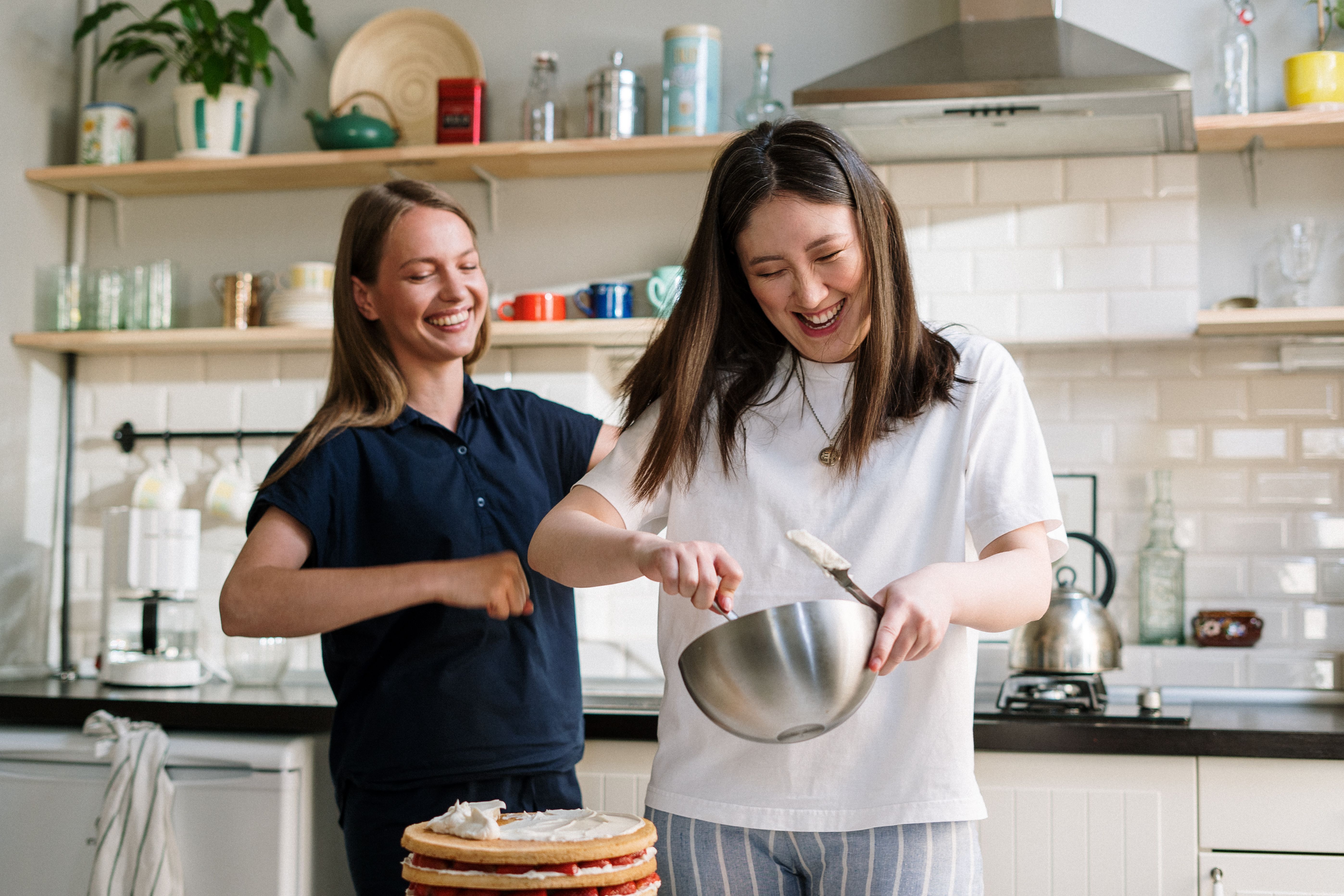 A group of people of different ages and nationalities participating in a Spanish cooking class, laughing and interacting.